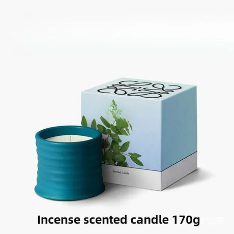 Teal incense scented candle with packaging on a white background