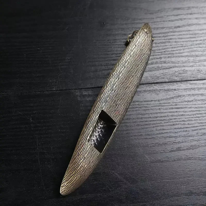 Bronze-colored metal object on a dark wooden surface