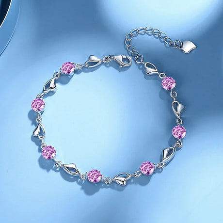 Silver bracelet with pink gemstones on a light blue background