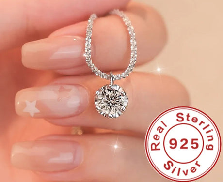 Silver earring with round gemstone held between fingers, Andara brand visible