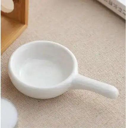 White ceramic scoop on a beige surface