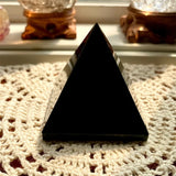 Black triangular object on a textured surface with blurred background