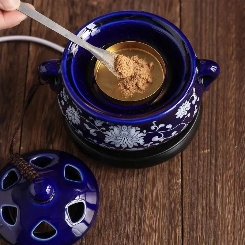 Blue ceramic pot with floral patterns on a wooden surface, containing a spoonful of brown powder.