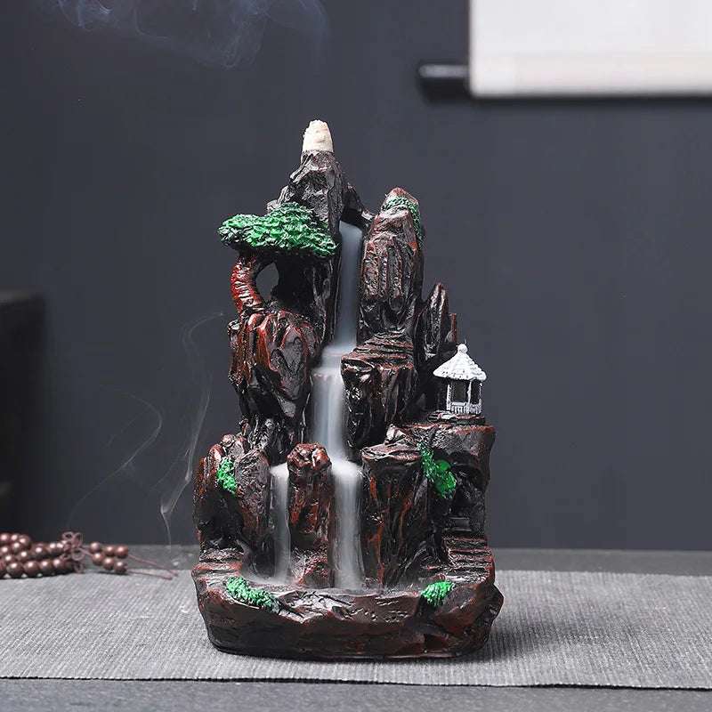 Decorative mountain-like structure with a waterfall and lantern on a dark background