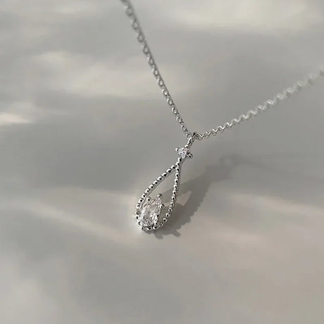 Silver teardrop necklace on a light background