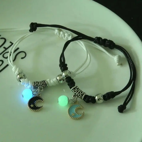 Two bracelets with moon charms on a white surface