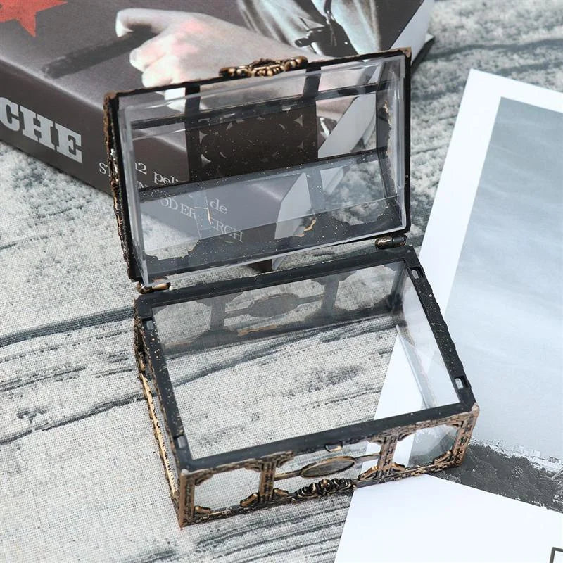 Open jewelry box with transparent lid on a textured surface