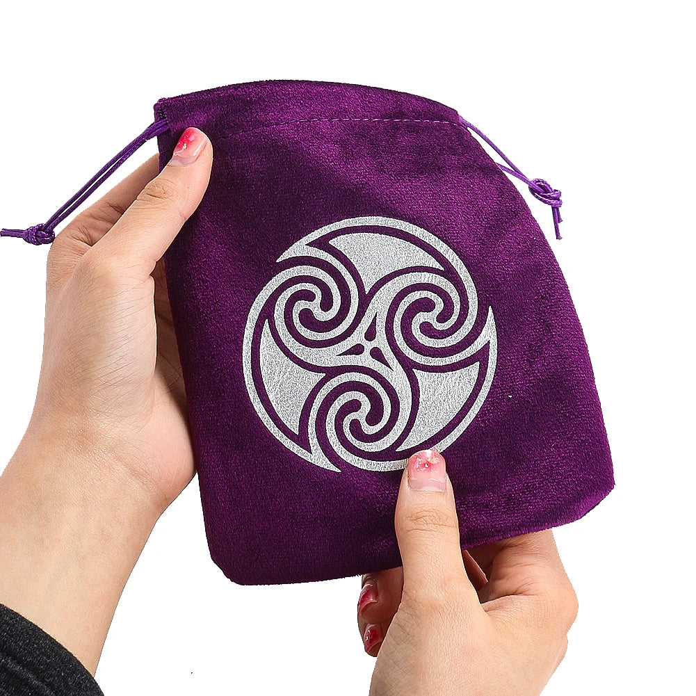 Purple drawstring bag with a silver triskele symbol held by a hand on a white background
