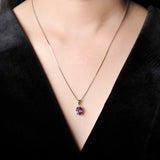 Necklace with a purple pendant worn by a person in a black outfit