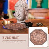 Buddhist-themed decor with statue, incense, and decorative plate on a wooden surface.