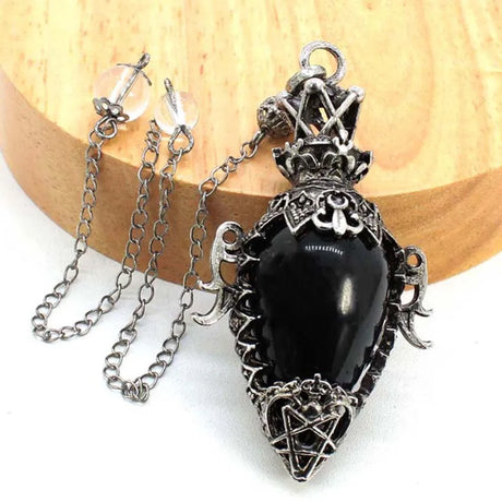 Black stone pendant with silver chain on a wooden surface
