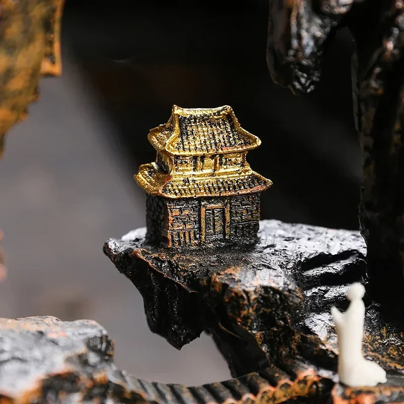 Small golden temple figurine on a dark rock surface