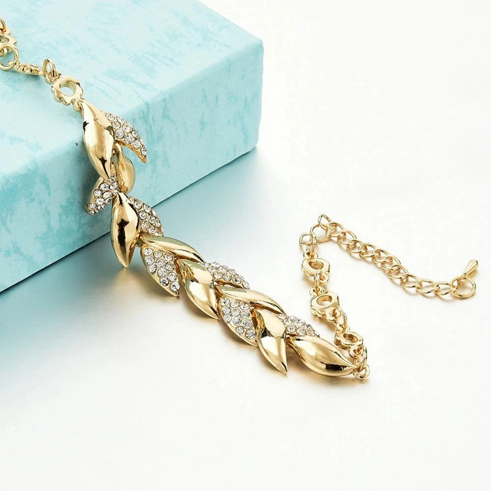 Gold necklace with leaf design on a light blue box background