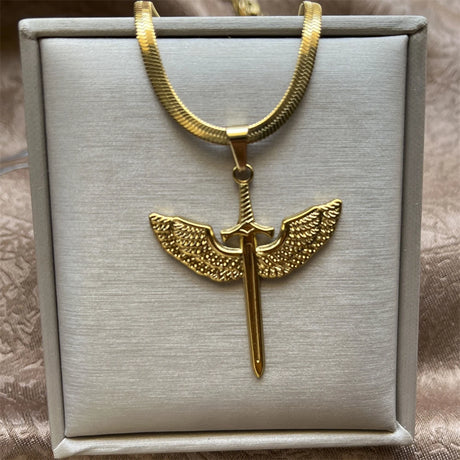 Gold necklace with a unique pendant on a gray box