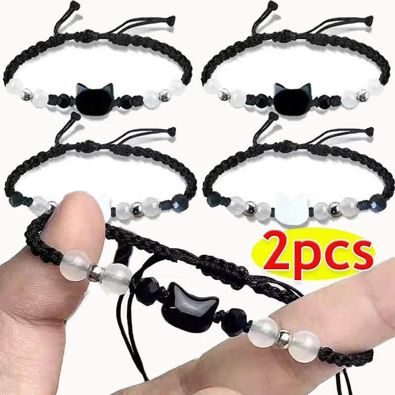 Two black cat-themed bracelets with beads on a white background