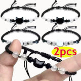 Two black cat-themed bracelets with beads on a white background