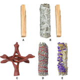 Collection of smudging tools including wooden sticks, sage bundles, and a wooden holder on a white background.
