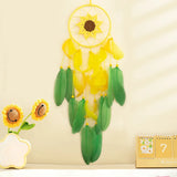 Decorative dreamcatcher with sunflower design on a beige wall.