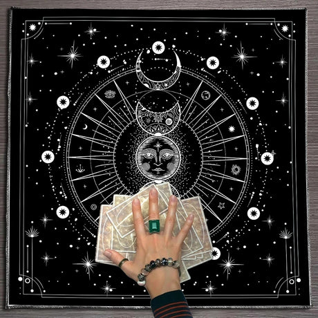 Person holding tarot cards with a black and white astrological design in the background