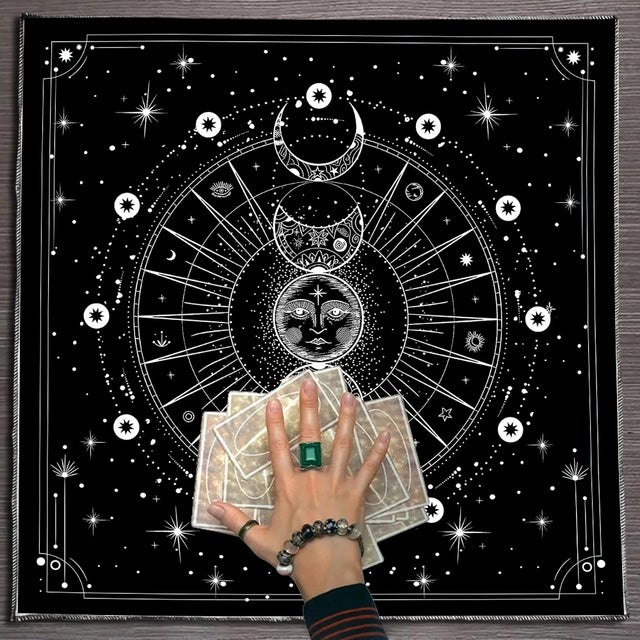 Person holding tarot cards with a black and white astrological design in the background