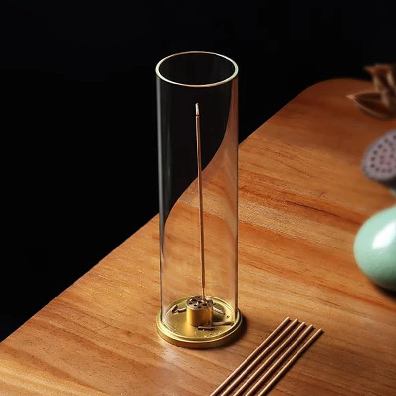 Cylindrical glass object with metallic base on a wooden surface