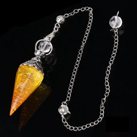 Crystal pendulum with yellow cone and silver chain on a dark background