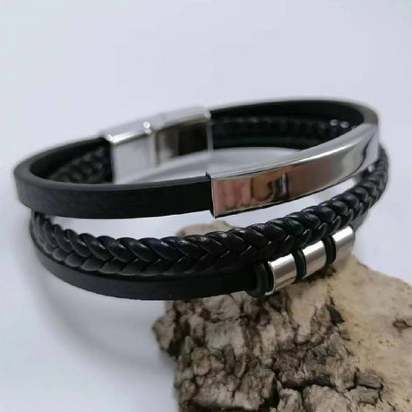 Black braided leather bracelet with silver clasp on a light gray background