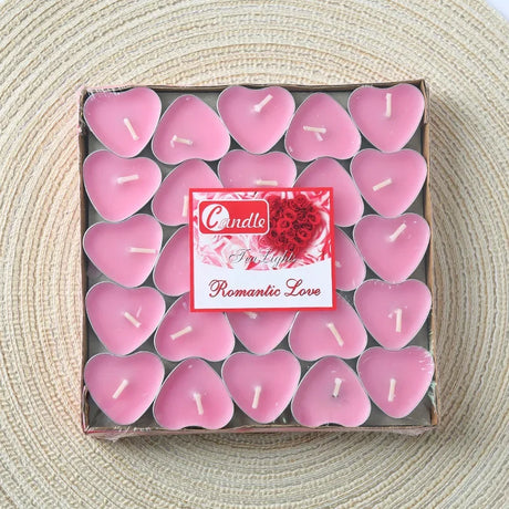 Box of pink heart-shaped candles with a 'Romantic Love' label on a textured surface.