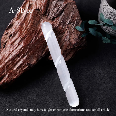 White crystal wand on a dark surface with natural elements