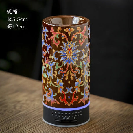 Decorative cylindrical lamp with floral patterns on a wooden surface