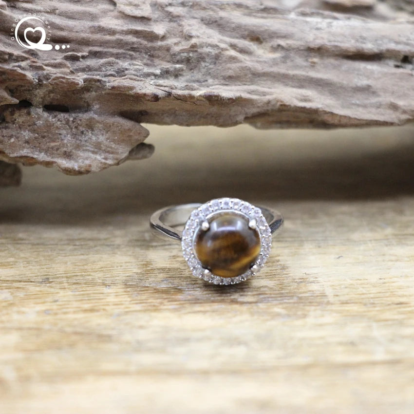 Ring with a tiger's eye stone on a wooden surface