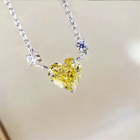 Heart-shaped yellow gemstone necklace with silver chain on a blurred background