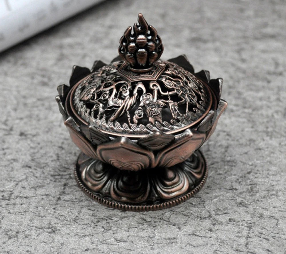 Decorative bronze incense burner with intricate designs on a gray surface