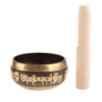 Tibetan singing bowl with gold script and wooden striker on a white background