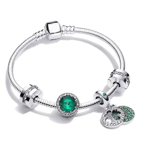 Silver bracelet with green gemstone charms on a white background