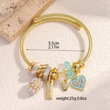 Gold bracelet with charms on a light beige background