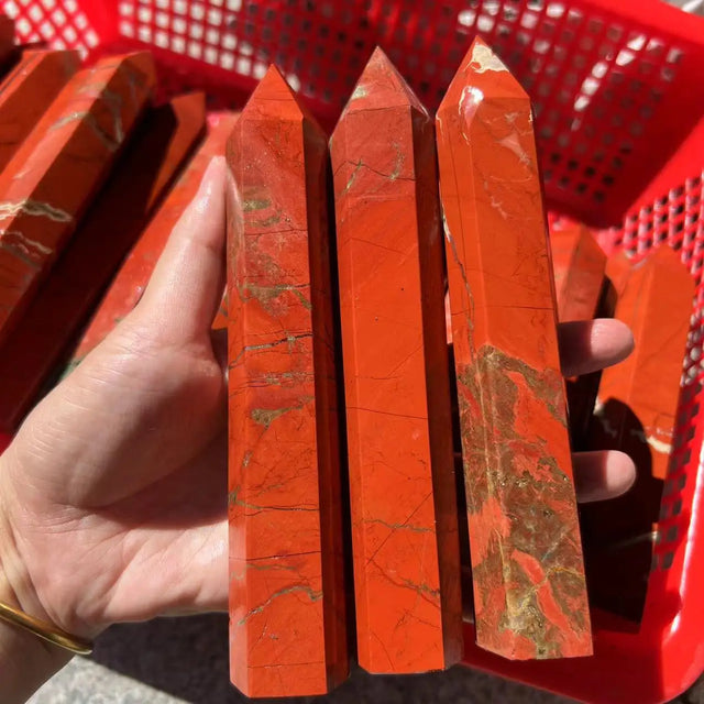 Red crystal sticks held by a hand with a red basket in the background