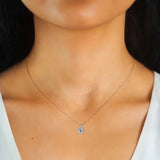 Necklace with a pendant on a person wearing a white top