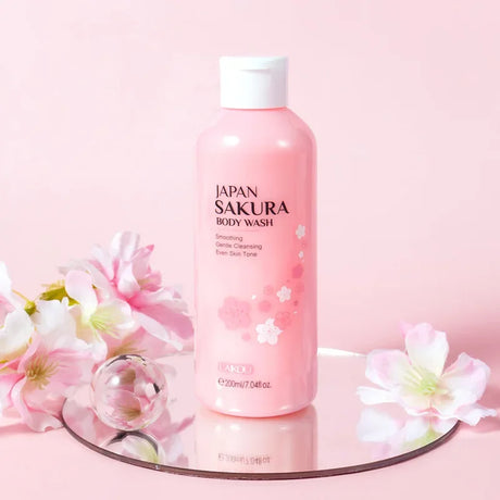 Pink bottle of Sakura body wash with cherry blossoms on a pink background