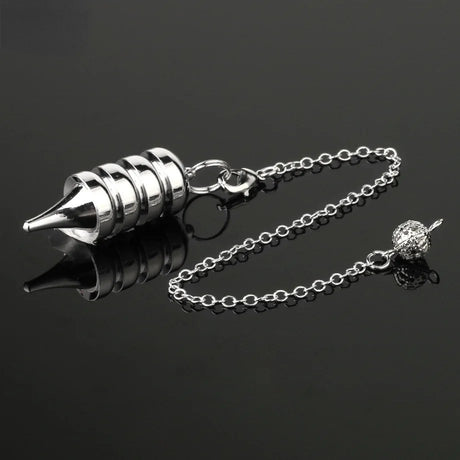 Silver metal tool with chain on a black background