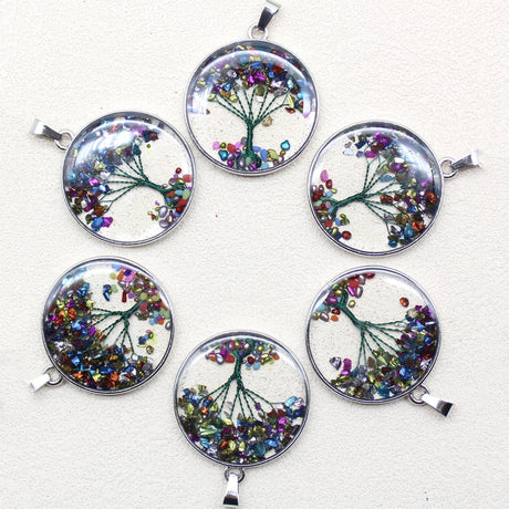 Set of six circular pendants with tree designs and colorful gemstones on a white background