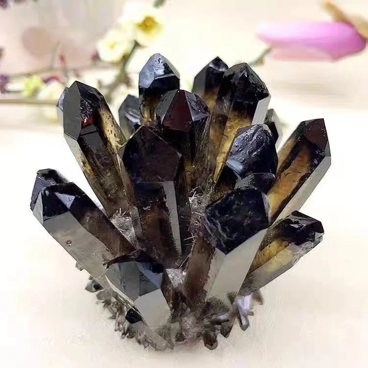 Group of dark crystal formations on a white surface with blurred background