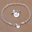 Silver bracelet with a '925' tag on a beige background