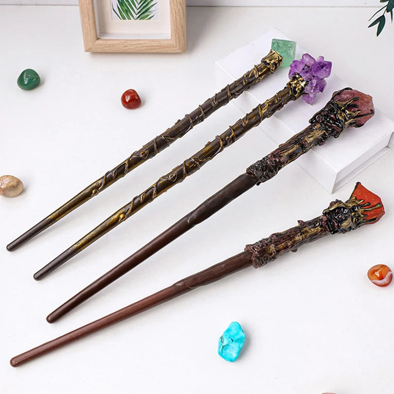 Three decorative wands with ornate handles on a white surface with colorful stones.