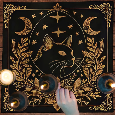 Decorative mat with a gold cat design, candles, and a hand on a wooden surface