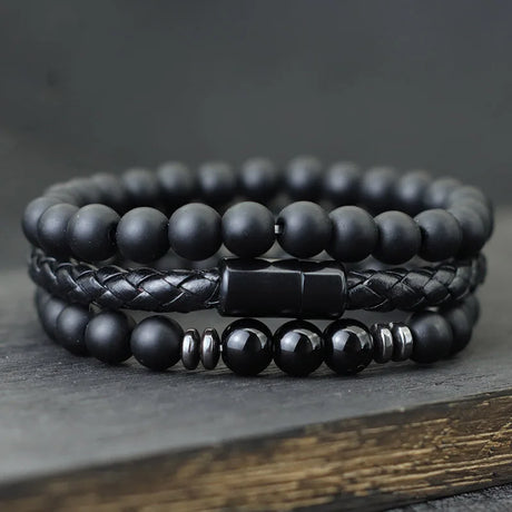 Stack of black beaded bracelets on a dark surface