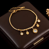 Gold bracelet with charms on a dark brown surface