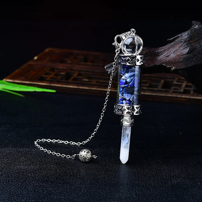 Decorative object with blue gemstones and silver chain on a dark background