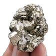 Mineral specimen held between fingers against a white background