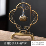 Bronze incense burner with floral design on a wooden surface